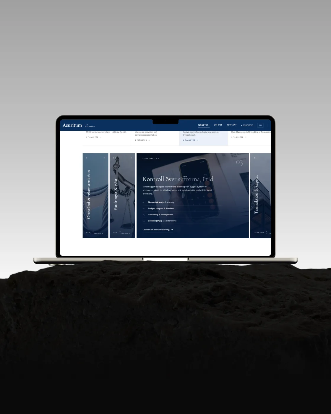 Acuritum Law & Economy — hemsida byggd av Binici, i en laptop på en sten